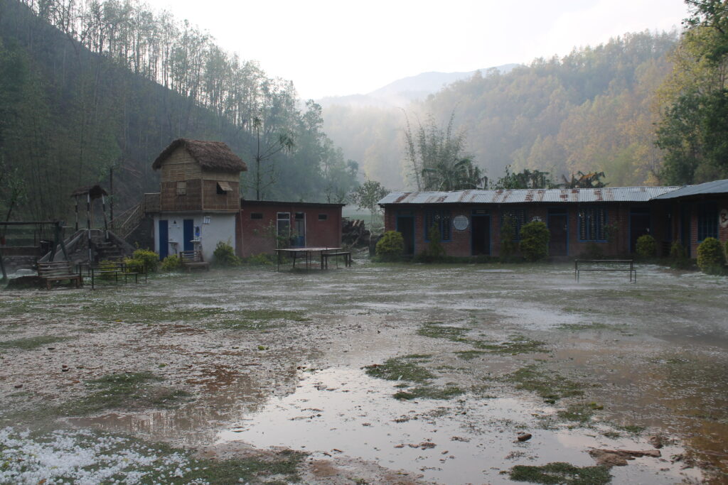 Classrooms and playground flied of school. Puddles and mist in the air after the rain.